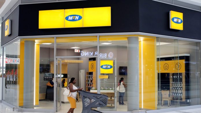 A shopper walks past an MTN shop at mall in Johannesburg