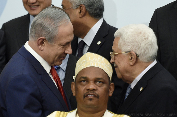TOPSHOTS Israeli Prime Minister Benjamin Netanyahu (L) talks with Palestine's president Mahmud Abbas (R) behind Comoros' President Ikililou Dhoinine during the family photo during the COP21, United Nations Climate Change Conference, in Le Bourget, outside Paris, on November 30, 2015. More than 150 world leaders are meeting under heightened security, for the 21st Session of the Conference of the Parties to the United Nations Framework Convention on Climate Change (COP21/CMP11), also known as "Paris 2015" from November 30 to December 11. AFP PHOTO / POOL / MARTIN BUREAU / AFP / POOL / MARTIN BUREAU